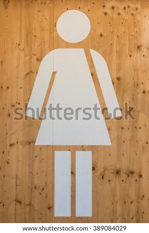 Female WC Sign, White Restroom Symbol on Wooden Background