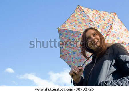  Picture of a young happy smiling girl standing under the rain with umbrella