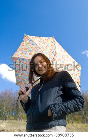  Picture of a young happy smiling girl standing under the rain with umbrella