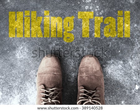 Old brown leather shoes on the floor background with text "Hiking Trail"