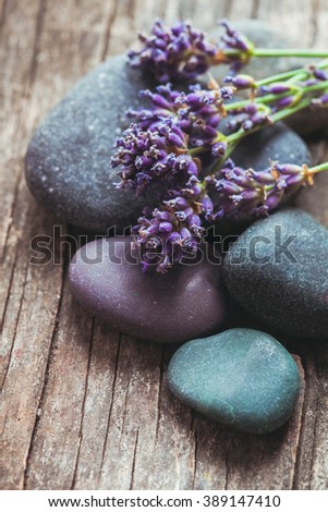 Stones with lavender on old shabby wooden background