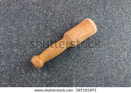 Wooden Kitchen Smasher on Dark Rustic Table. Royalty-Free Stock Photo #389185891