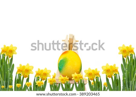 Frame daffodils with easter egg on an easel in front of a white background.