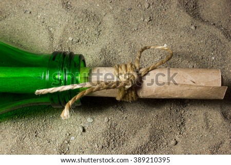 Message in a bottle. A roll of paper in a bottle on the sand.