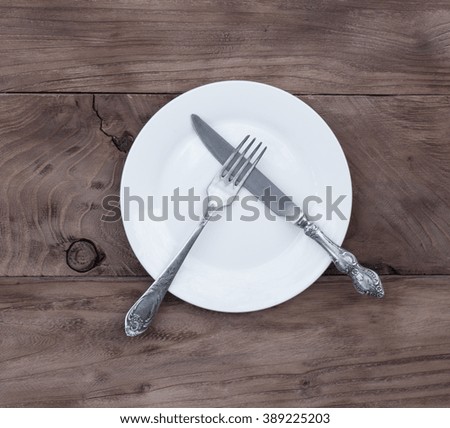cutlery, knife, fork, plate on a wooden table