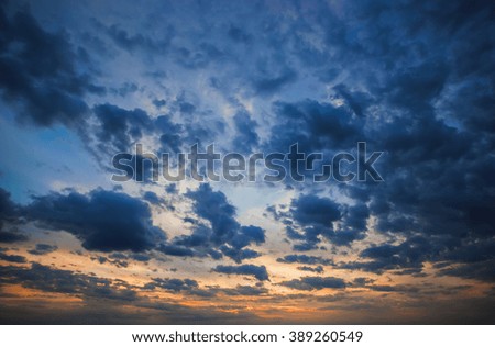 Big blue clouds on the sunset background.