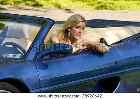 beautiful blond sitting in a blue convertible sport car