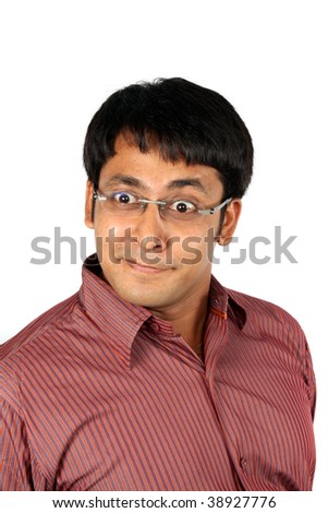 A portrait of an Indian guy making funny faces, on white studio background.