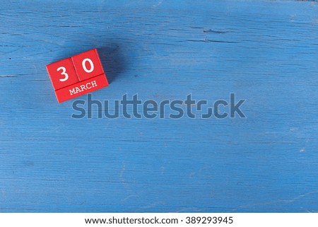March 30, Cube calendar on wooden surface with copy space