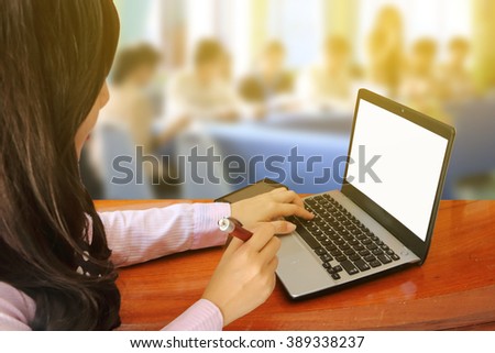 blur image of woman using laptop with blur people in meeting room