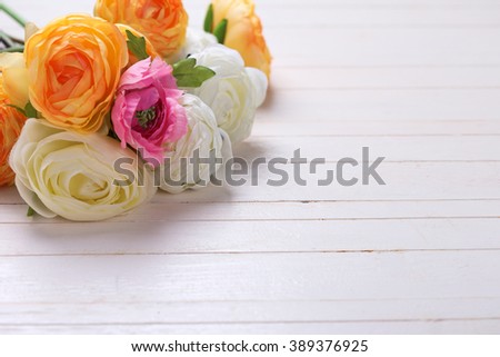 Border from  pink, white and yellow flowers  on white wooden background. Selective focus. Place for text. 