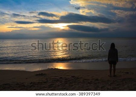 Sunrise at Cha-am beach in Thailand with cloudy sky and alone girl in a picture.