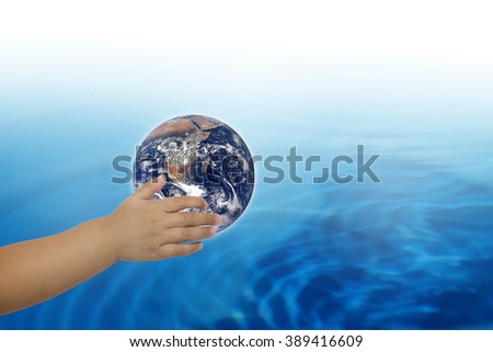 Planet in human hands on blurred beautiful nature background. Investment, Ecology, World Environment Day, Elements of this image furnished by NASA.