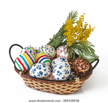 Easter eggs in wicker basket and flower on white background