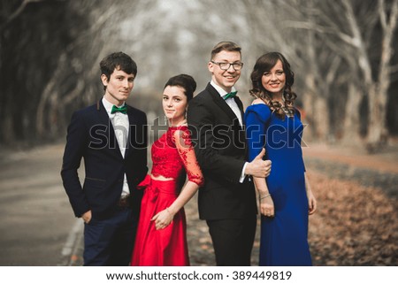 Bridesmaids and groomsmen of wedding couple posing in park 