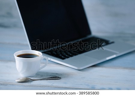 Workspace work desktop with laptop an cup of coffee with spoon on the wooden table vintage background