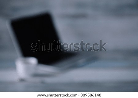 Workspace with laptop an cup of coffee on the wooden table vintage blurred background