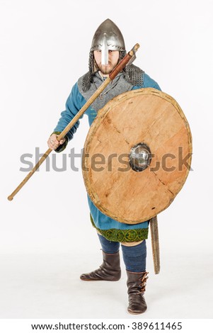 medieval slavic soldier standing and ready for a fight with axe, helmet, hauberks. image on white studio background. historical concept.