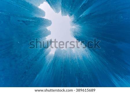 Translucent blue icicles in a frozen ice wall.