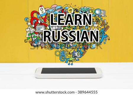 Learn Russian concept with smartphone on yellow wooden background