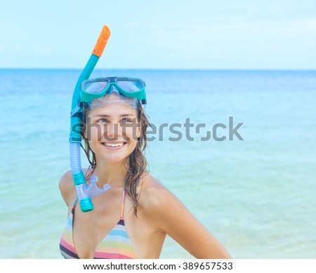 happy girl with a mask for snorkeling on a background of blue sea