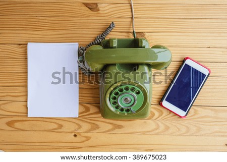 Old phone and Mobile phone on wood table background