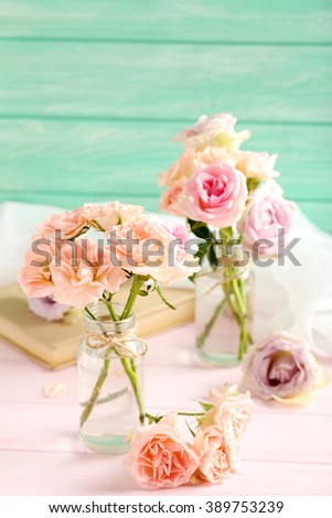 Bouquet of beautiful roses on a pink wooden table