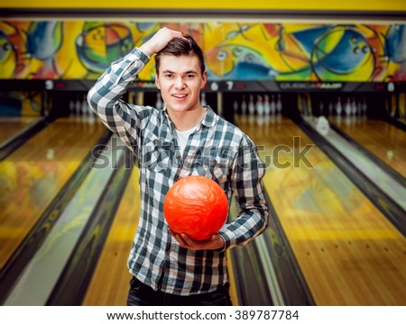 Young man at the bowling alley with the ball