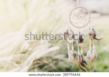 Close up of Dream Catcher on meadow background with soft vintage tone Royalty-Free Stock Photo #389796646