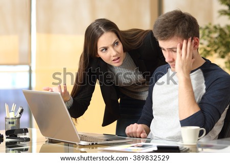 Boss scolding a shameful employee at work in an office Royalty-Free Stock Photo #389832529