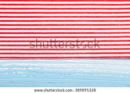 Red textile, napkin, tablecloth on blue wooden kitchen table. View from above, top with copy space. Traditional pattern and color.