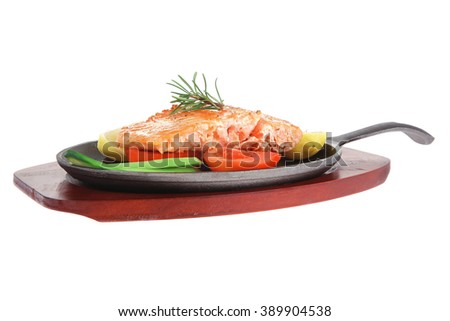 diet healthy food: hot grilled sea salmon fillet served on iron pan over wooden plate isolated on white background