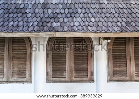 Wall in cafe with wooden shutters windows under tile roof