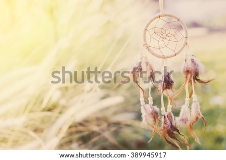 Close up of Dream Catcher on meadow background with soft vintage tone Royalty-Free Stock Photo #389945917