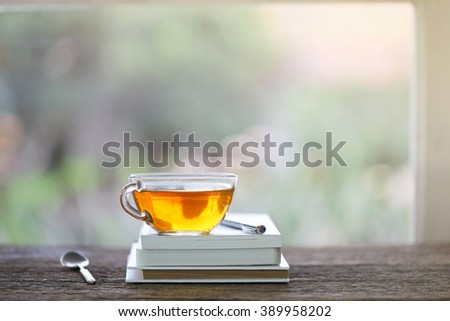 tea in glass and notebook with pencil at windows