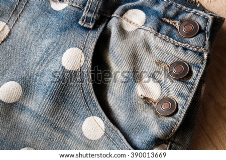 Closeup blue jean and white dots texture on wooden background. Image shallow depth of field.
