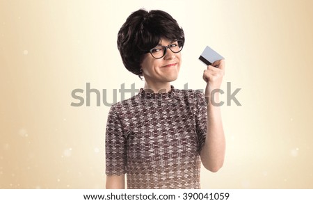 Girl holding a credit card over ocher background