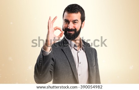 Man making OK sign over ocher background