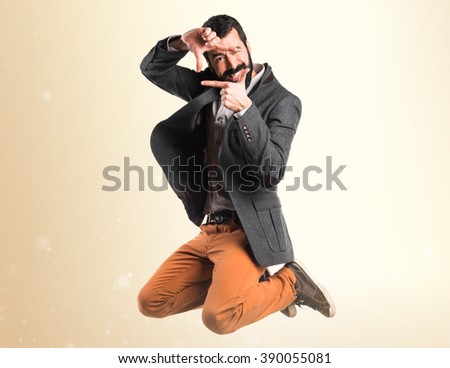 Man focusing with his fingers over ocher background