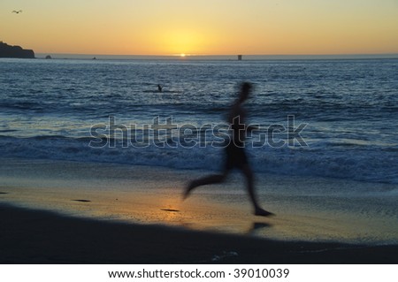 photo man running on the beach and sunset