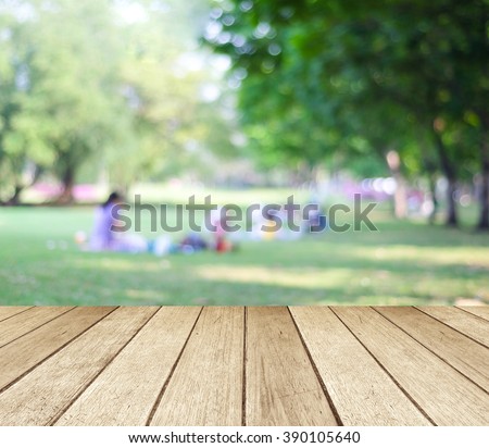 Table and summer park background, Blur family picnic at outside green tree garden background, Empty perspective wood table top over blur people at nature park in spring, summer backdrop, banner 