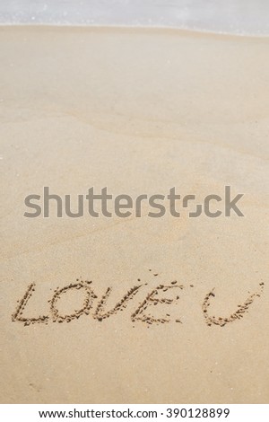 LOVE U sign on wet sand beach background closeup picture