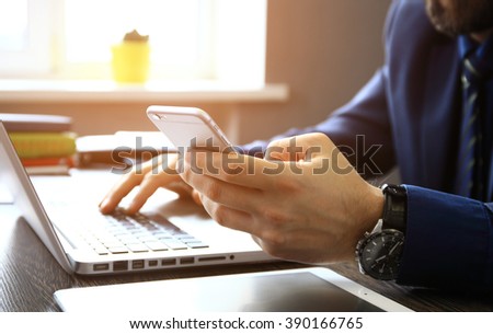 Young businessman working with modern devices, digital tablet computer and mobile phone. Royalty-Free Stock Photo #390166765