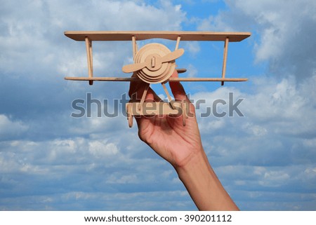 Wooden toy airplane flying in summer blue sky.Concept of imagination