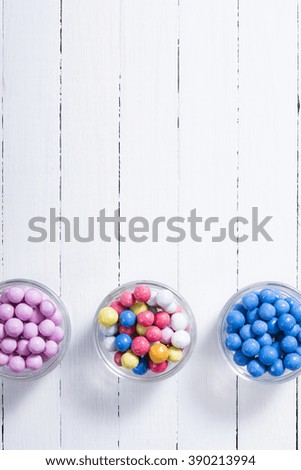 dragees, sugar coated pills on white wooden background