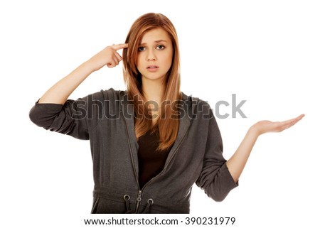 Teenage woman holding something on open palm and thinking about something