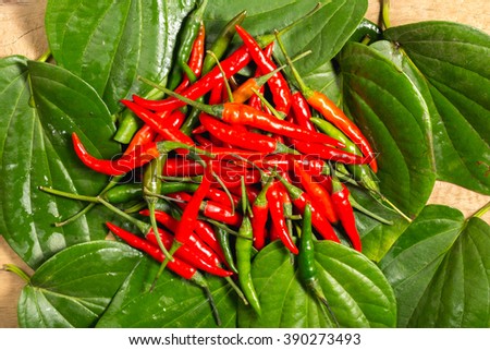 Red chilli on Green betel leaf heart shape.
