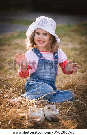 Pretty young girl .  Beautiful baby. Fancy hut, curly hair. Little coquette. 
Blue eye, portrait , photo