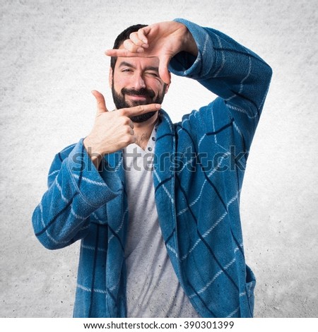 Man in dressing gown focusing with his fingers