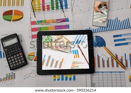 business workplace with digital tablet, mobile smartphone and some charts and graphs, pen